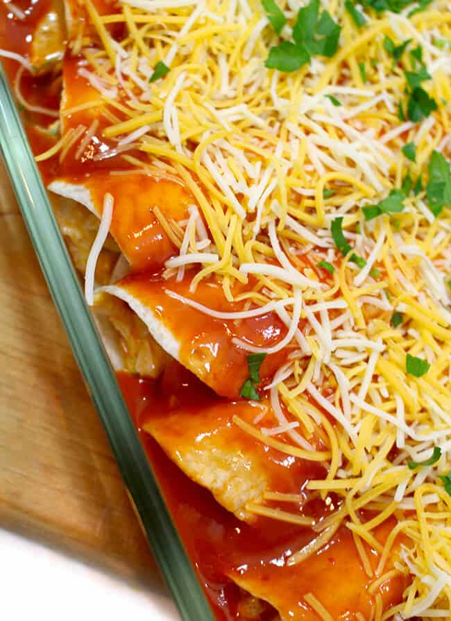 Finished enchiladas in a baking dish to put in oven, topped with parsley