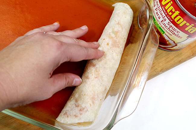 Putting rolled enchiladas tortillas into the baking dish